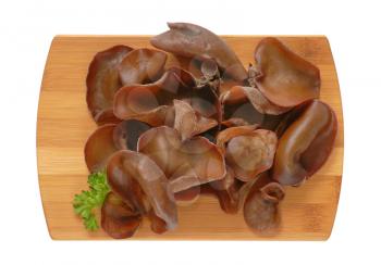 heap of wood ear mushrooms on wooden cutting board
