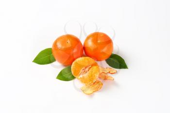 fresh seedless tangerines - peeled and unpeeled on white background