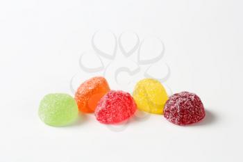 fruit jelly candies coated with sugar on white background