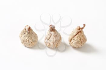 three dried figs on white background