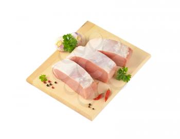 Slices of fresh boneless pork loin on cutting board