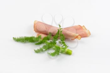 ham slices with dill on white background