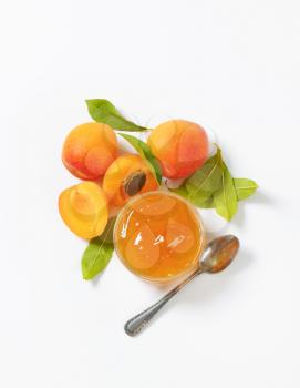fresh apricots and bowl of apricot jam on white background