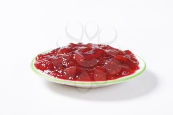plate of strawberry jam on white background