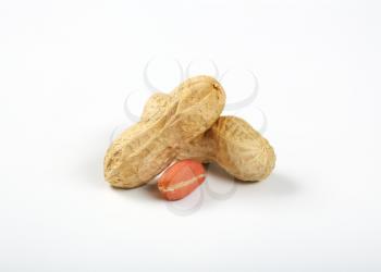 peeled and unpeeled peanuts on white background