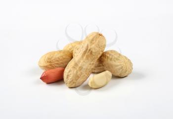 peeled and unpeeled peanuts on white background