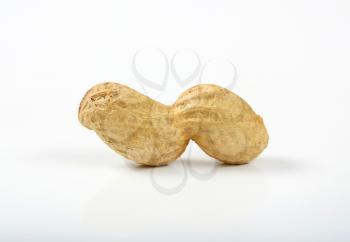 unpeeled peanut in shell on white background