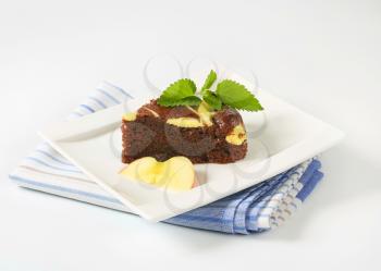 slice of chocolate cake with cream cheese on white square plate