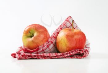 two ripe apples on checkered dishtowel