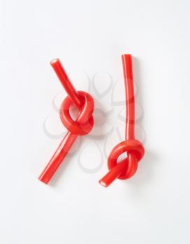 knotted soft strawberry candy sticks on white background