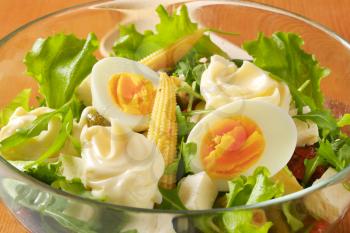bowl of mixed salad with eggs and baby corn - close up