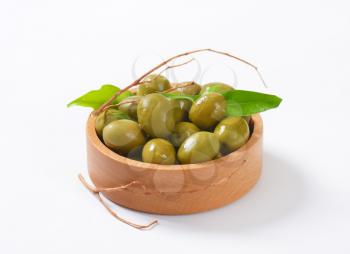 bowl of green olives on white background