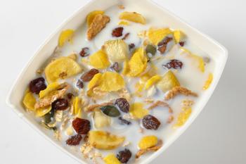 bowl of corn flakes and cereals with fresh milk - close up
