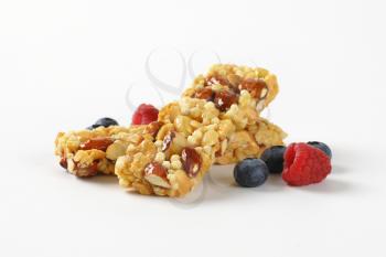 two snack bars with almonds and peanuts on white background