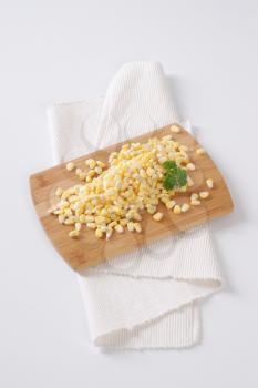 pile of sweet corn kernels on wooden cutting board