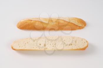 halved french baguette on white background