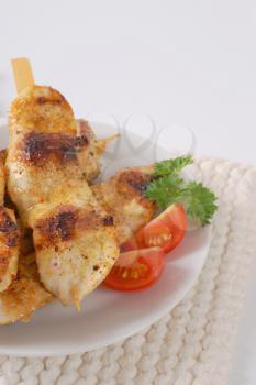 grilled chicken skewers on white plate
