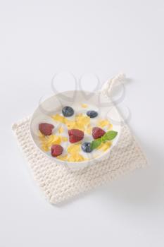 plate of corn flakes with milk and fresh berry fruit