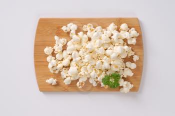 pile of fresh popcorn on wooden cutting board