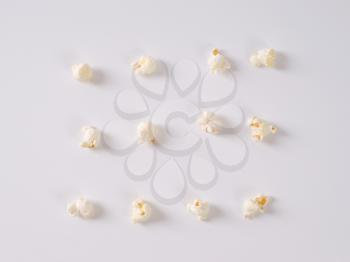 pieces of fresh popcorn arranged in rows on white background
