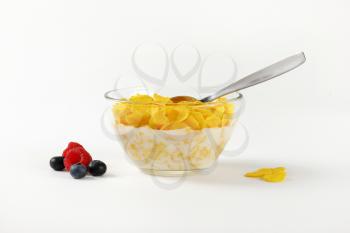 bowl of corn flakes with fresh milk on white background