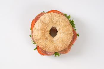 bagel sandwich with salami on white background