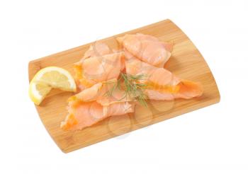 Thin smoked salmon slices on cutting board