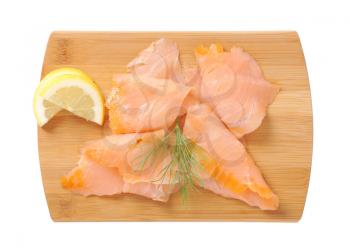 Thin smoked salmon slices on cutting board