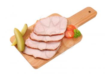 Thin slices of smoked pork roast on cutting board
