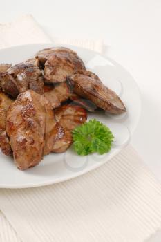 plate of pan fried chicken liver on white place mat