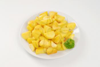 plate of pan fried potatoes on white background