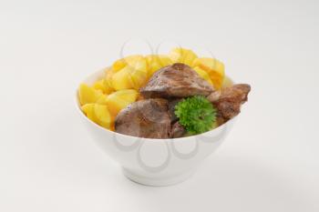 bowl of pan fried potatoes and chicken liver on white background