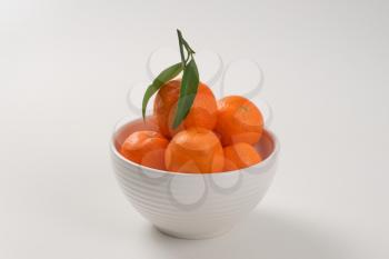 bowl of fresh tangerines on white background