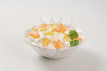 bowl of sour cream with fresh tangerine and corn flakes