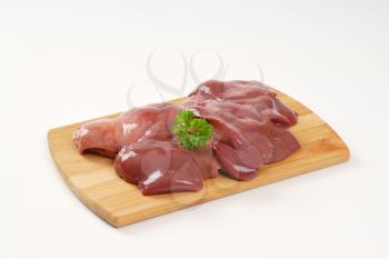 raw chicken liver on wooden cutting board