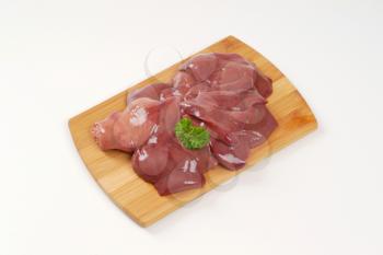 raw chicken liver on wooden cutting board
