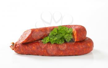 spicy sausage and fresh parsley on white background