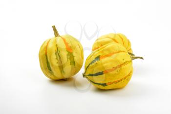 three small striped pumpkins on white background
