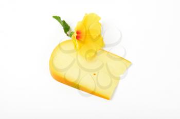 slice of gouda cheese with hibiscus flower on white background