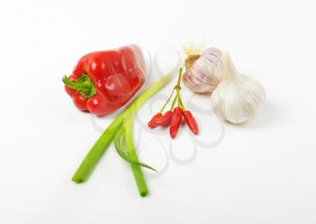 Red sweet pepper, chili peppers, scallion and garlic on white background