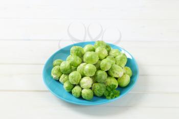 plate of raw Brussels sprouts on white background