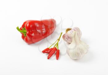 Red sweet pepper, chili peppers and garlic on white background