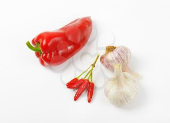 Red sweet pepper, chili peppers and garlic on white background