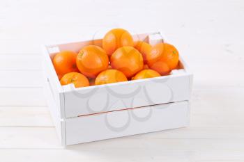 box of fresh oranges on white background