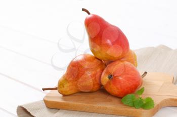 ripe red pears on wooden cutting board - close up