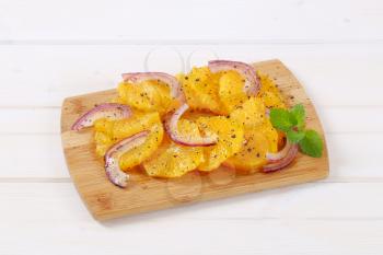 Sicilian orange salad with onion and pepper  on wooden cutting board
