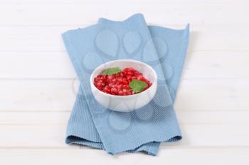 bowl of pomegranate seeds on blue place mat