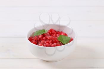 bowl of pomegranate seeds on white background