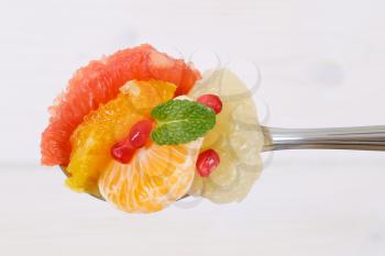 Spoonful of citrus fruit salad with pomegranate seeds
