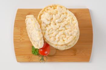 stack of puffed rice bread slices on wooden cutting board